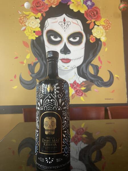 Dame Más Reserva against the Día de los Muertos mural at Fiesta Jalisco