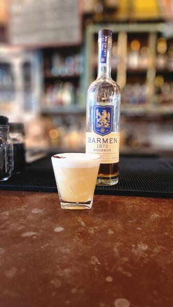 Barmen 1873 bourbon whiskey sour with a bitters heart at the bar